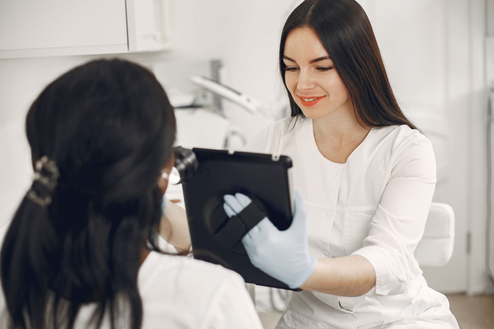 Beautician consulting an adult client with a tablet
