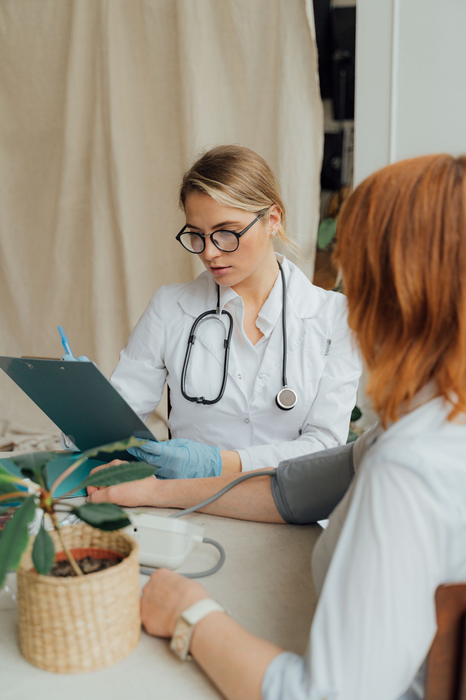 Doctor checking a patient's blood pressure during a consultation.